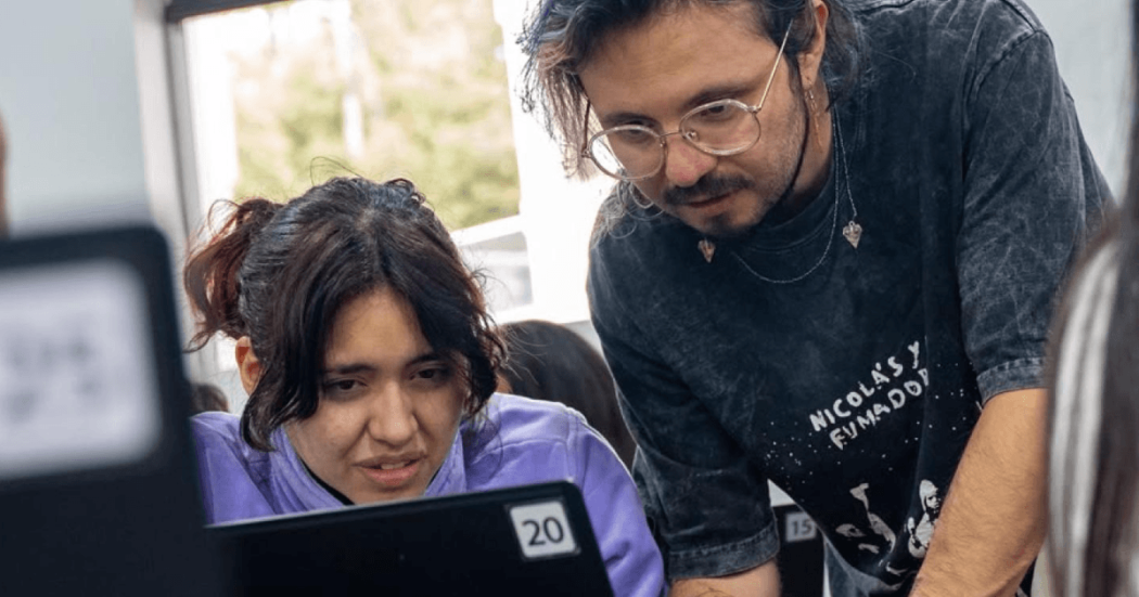 Una mujer y un hombre mirando la pantalla de un computador.