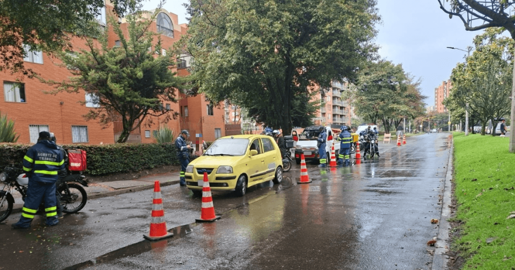 Foto que muestra personas, carros y policías 