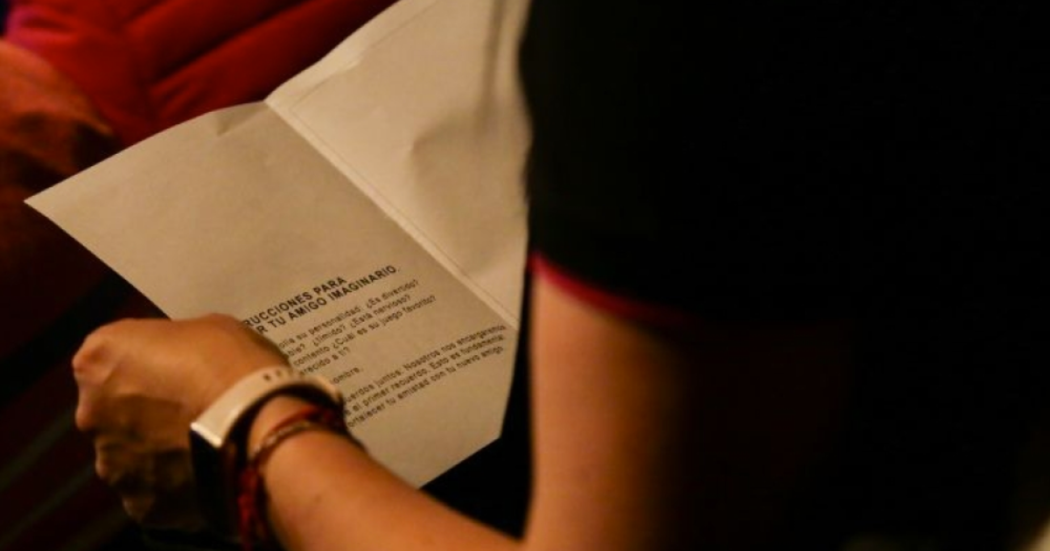 Imagen de una mujer de espalda, sentada leyendo un libro.