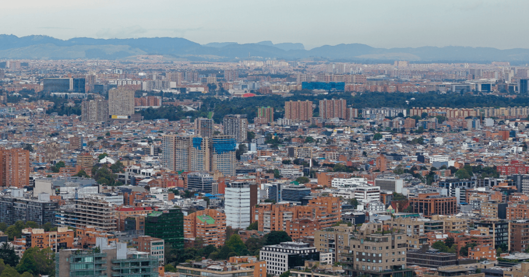 Vista panorámica de Bogotá desde un punto elevado, con numerosos edificios residenciales y comerciales de diferentes alturas que se extienden por la ciudad.