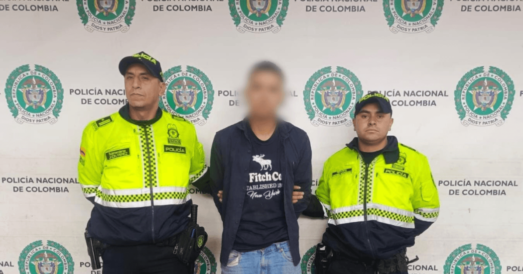 Foto de hombre capturado en medio de dos policías.