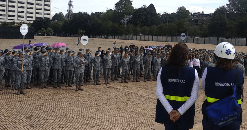 Personal uniformado y equipos de respuesta se reúnen en formación durante un ejercicio de preparación para emergencias en un espacio abierto.