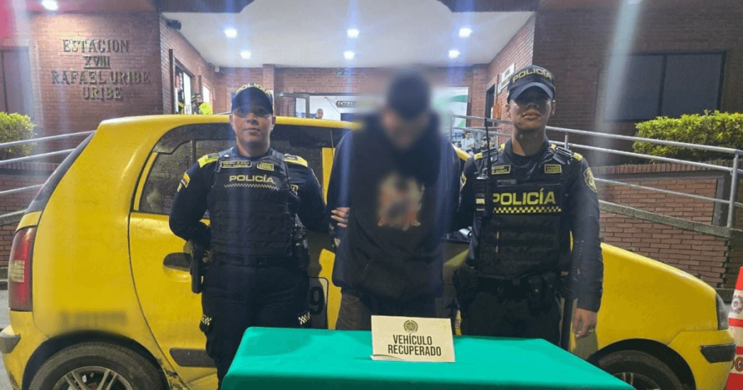 Foto de hombre capturado en medio de dos policías.