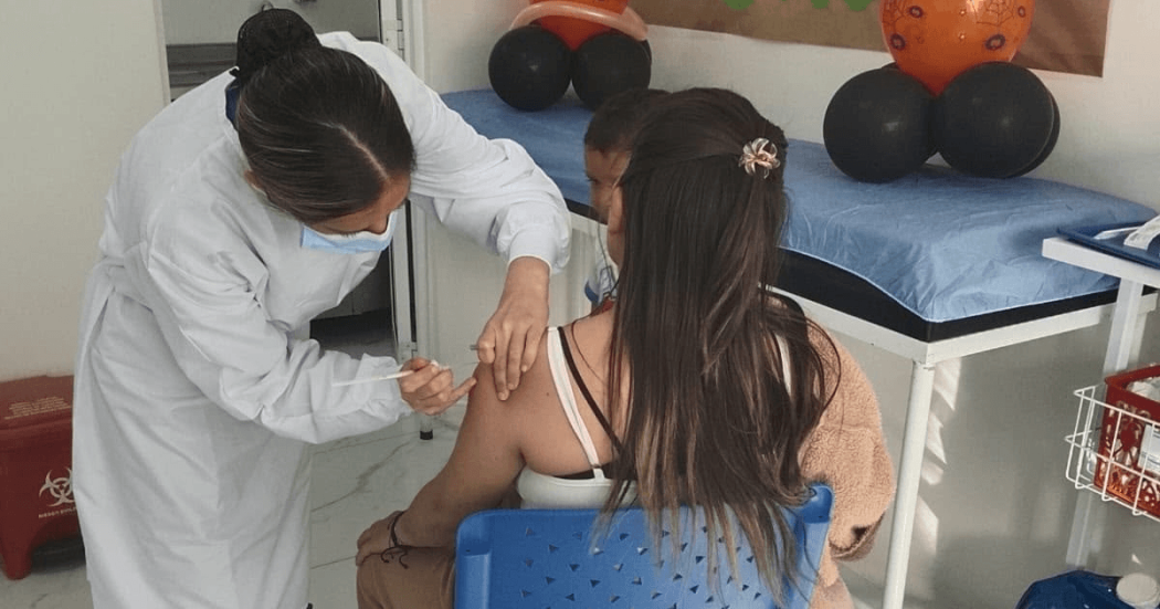 Foto que muestra una enfermera colocando una vacuna en un brazo 