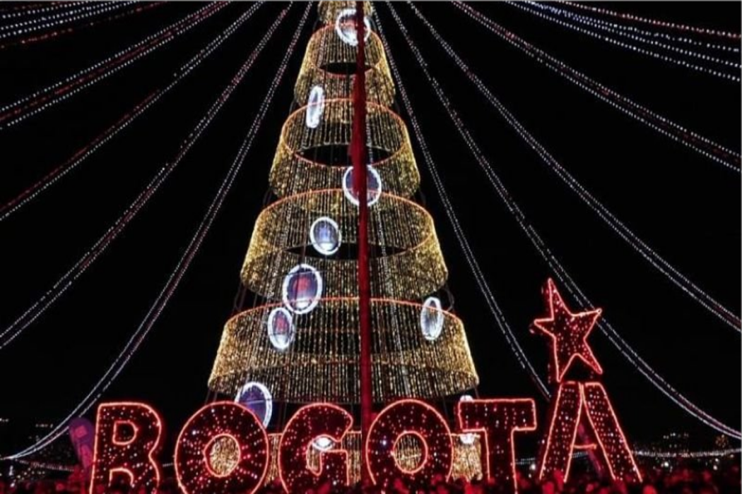 Un árbol de navidad, con muchas luces y enfrente la palabra "Bogotá" en luces rojas