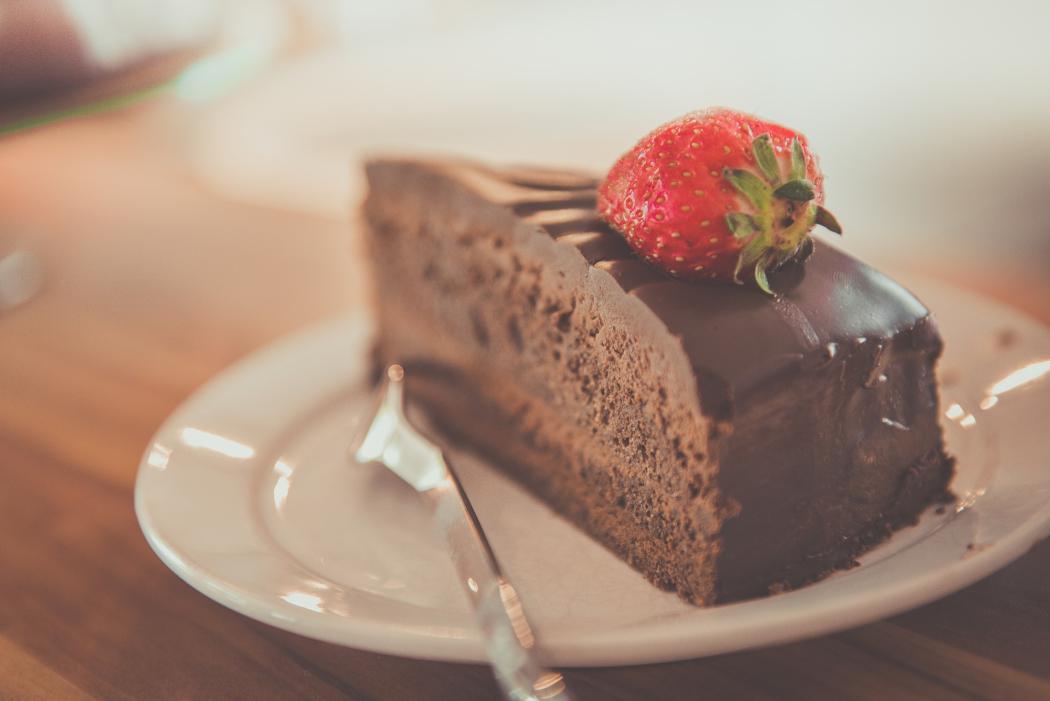 Un pedazo de pastel de chocolate con una fresa decorativa