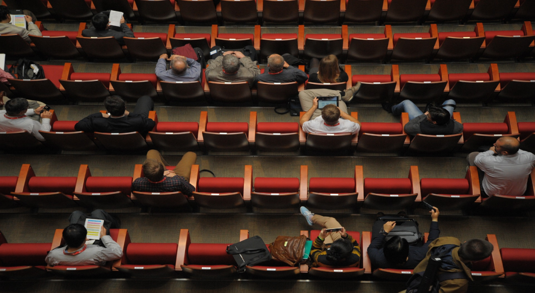 Varias personas sentadas en un auditorio 