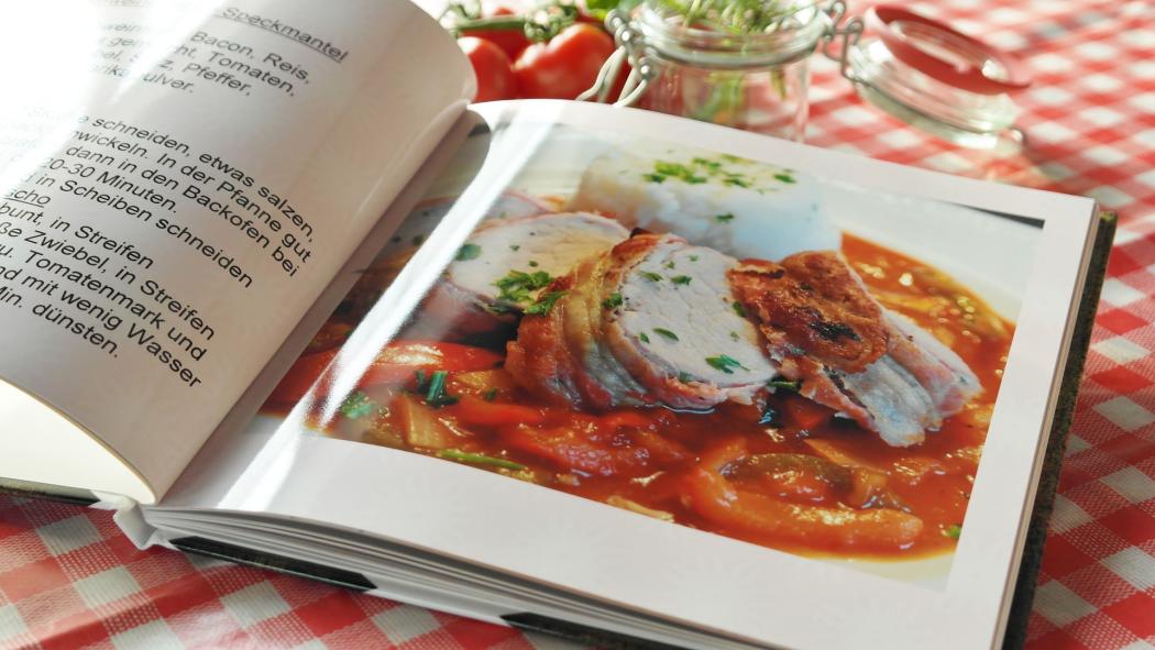 Un libro de cocina abierto, con una imagen de un plato
