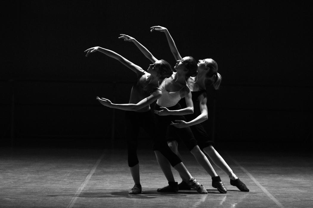 Tres mujeres realizando pasos de ballet en un escenario 