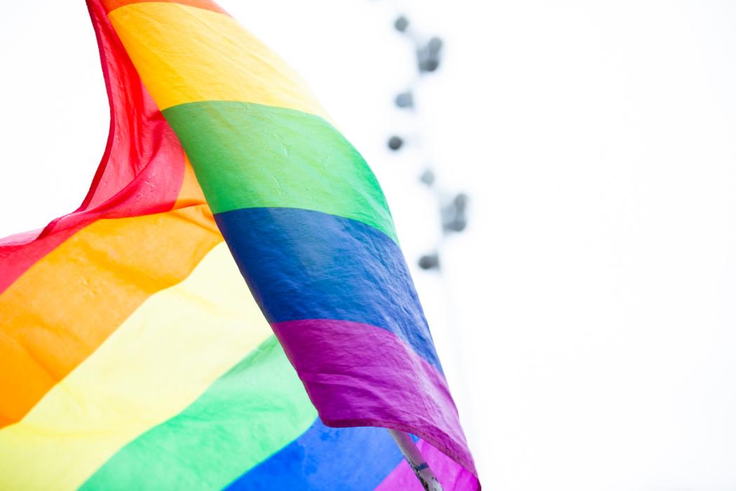 Una bandera LGBTI con los colores tradicionales del grupo ondeándose en el viento en la marcha LGBTI 