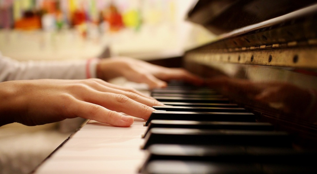 Primer plano de manos tocando el piano.