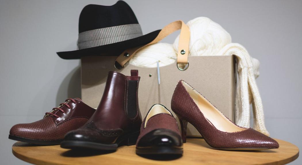 Zapatos de cuero de hombre y mujer, una cartera de dama y un sombrero.