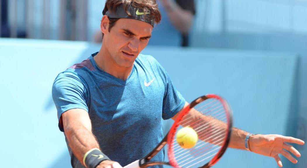Foto de Roger Federer vestido con camiseta azul sosteniendo una raqueta.