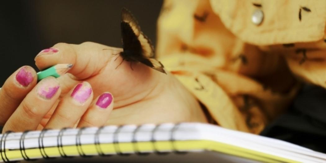 Mujer con un cuaderno y una mariposa