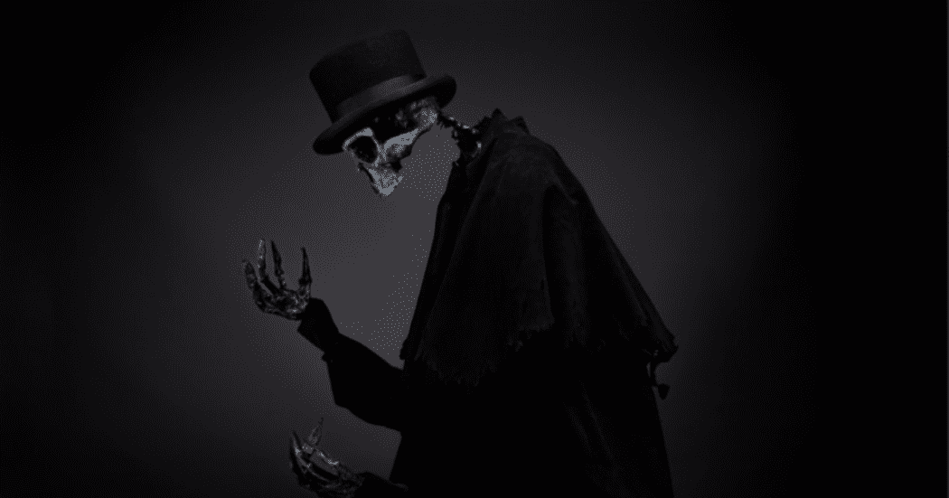 Foto de una figura esquelética vestida con capa negra y sombrero de copa