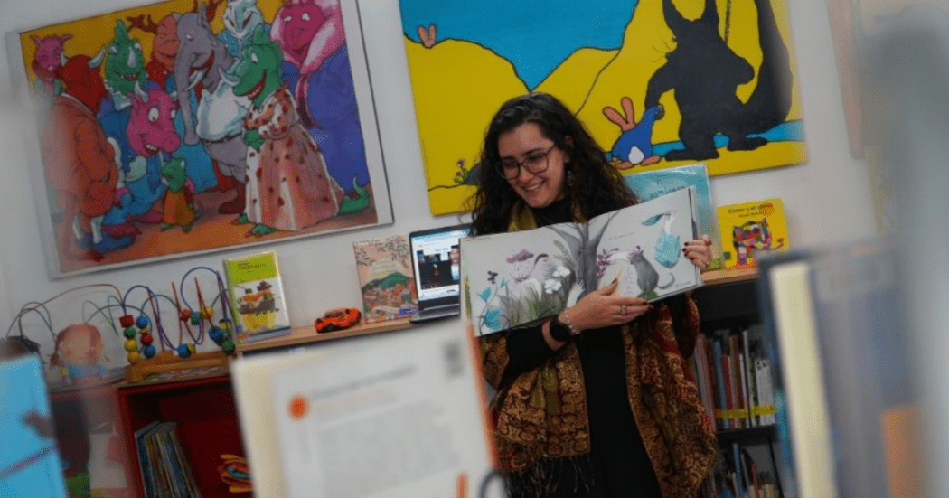 Foto de una mujer mostrando su dibujo. 