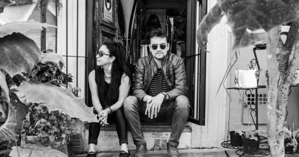 Imagen de un hombre y una mujer sentados a la entrada de una puerta