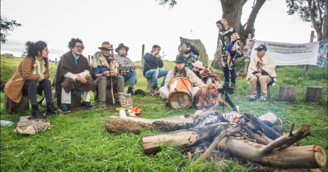 Fotografía de personas en ruana cantando alrededor de una fogata