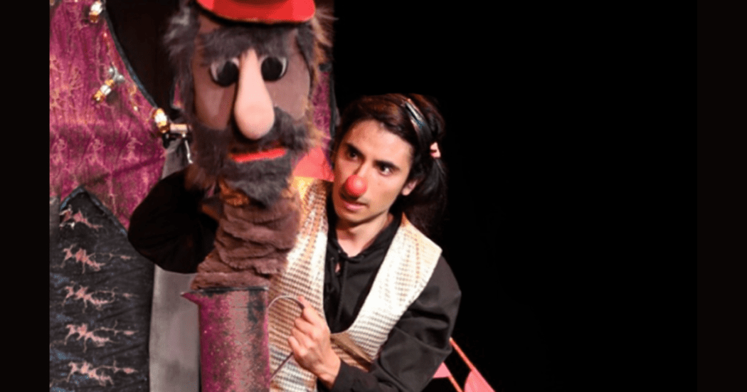 Imagen de un hombre que dialoga con Anuki un títere de gran formato 