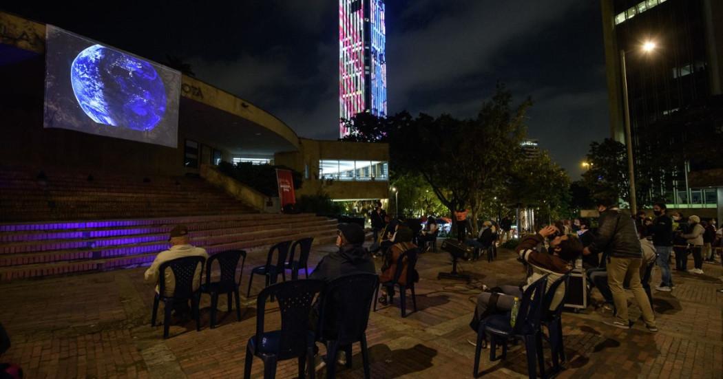 Imagen de personas mirando una pantalla afuera del Planetario