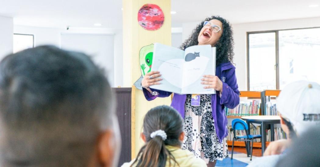 Imagen de una persona con un libro abierto sonriendo