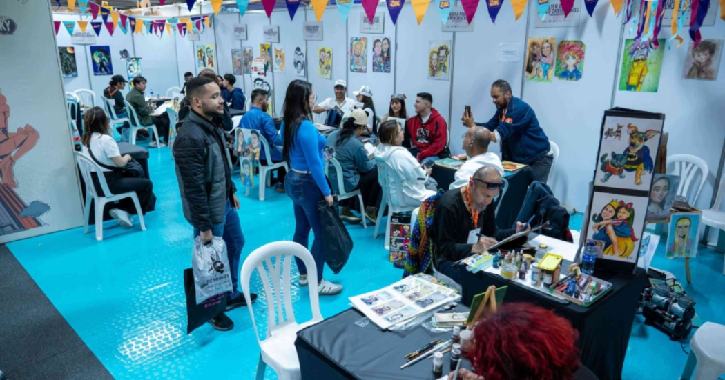 Imagen de varias personas en un salón donde distintos caricaturistas dibujan la foto de los asistentes