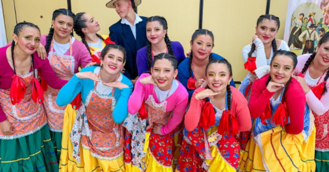 Imagen de un grupo de mujeres jóvenes vestidas con trajes típicos campesinos y de fondo un hombre también campesino