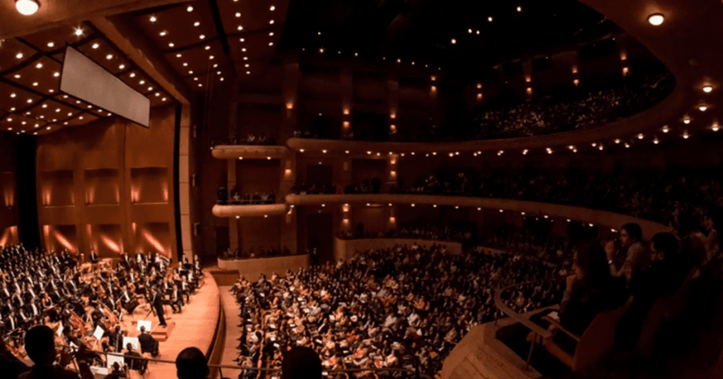 Foto de una orquesta interpreta ante un teatro lleno