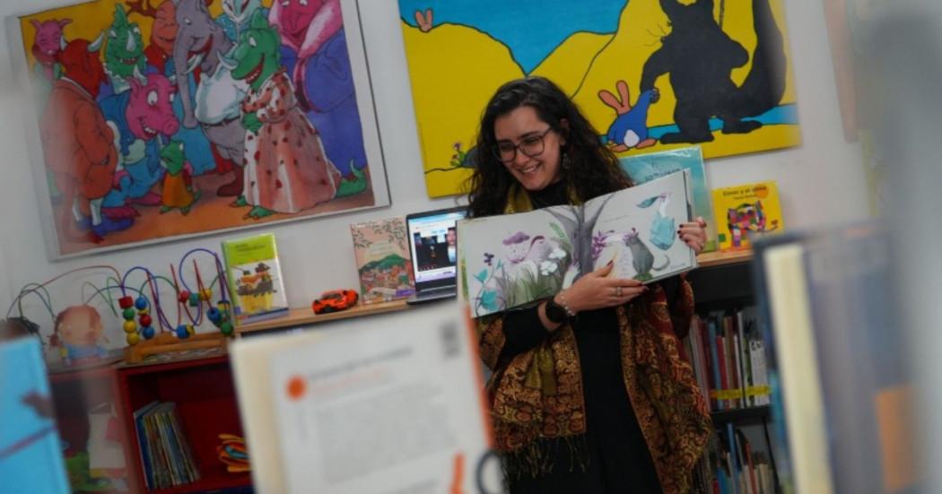 Imagen de una mujer enseñando un libro de dibujos 