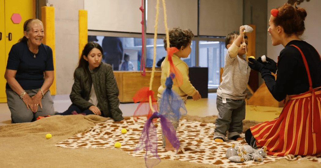 Imagen de varios bebés en taller de trapitud juntos a sus padres y cuidadores