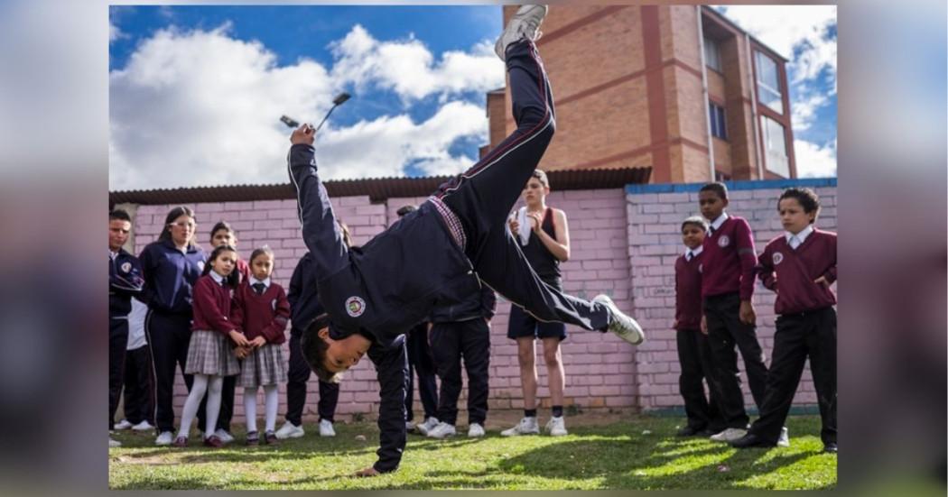 imagen de varios niños viendo como otro baila capoeira.