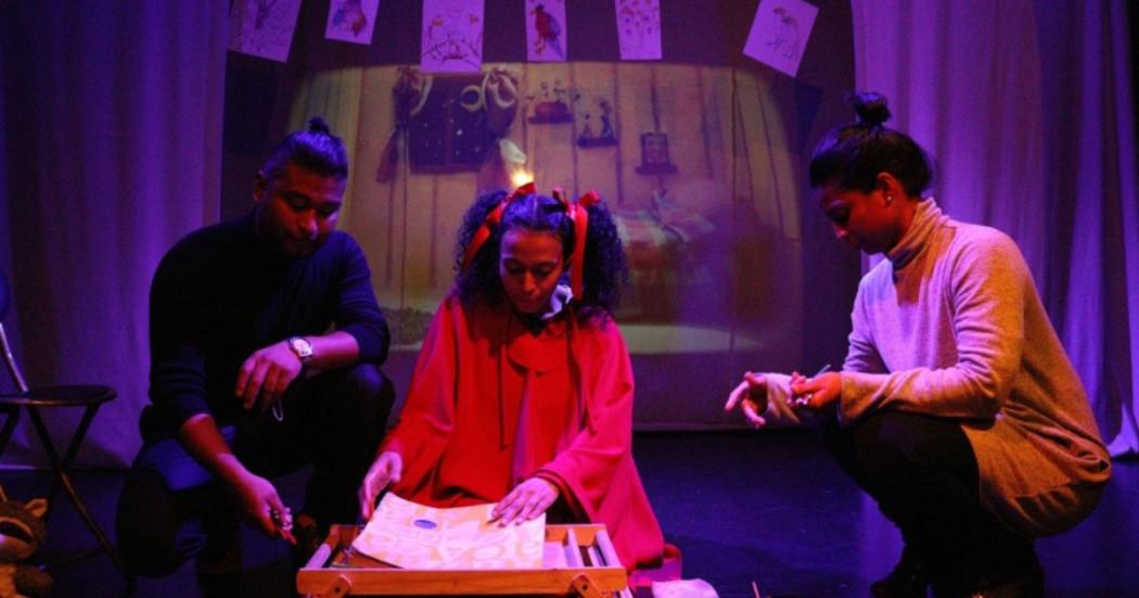 Imagen de 3 personas arrodilladas mirando una hoja