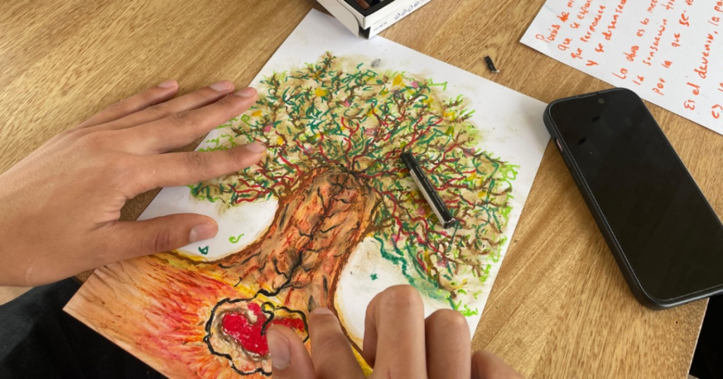 Imagen de una mano trabajando en su herbario pictórico.