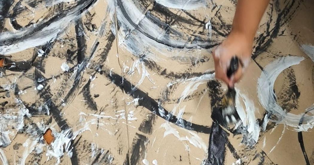 Imagen de mano pintando trazos sobre papel