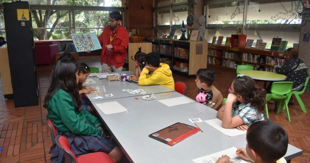 Foto que muestra niños y niñas sentados en una biblioteca