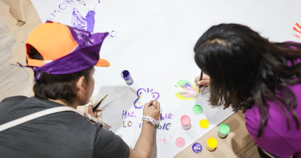 Imagen de personas pintando sobre cartelera