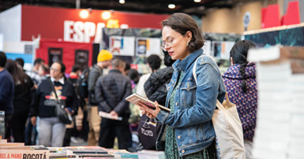 Imagen de una mujer observando un libro en la FILBo 2026.