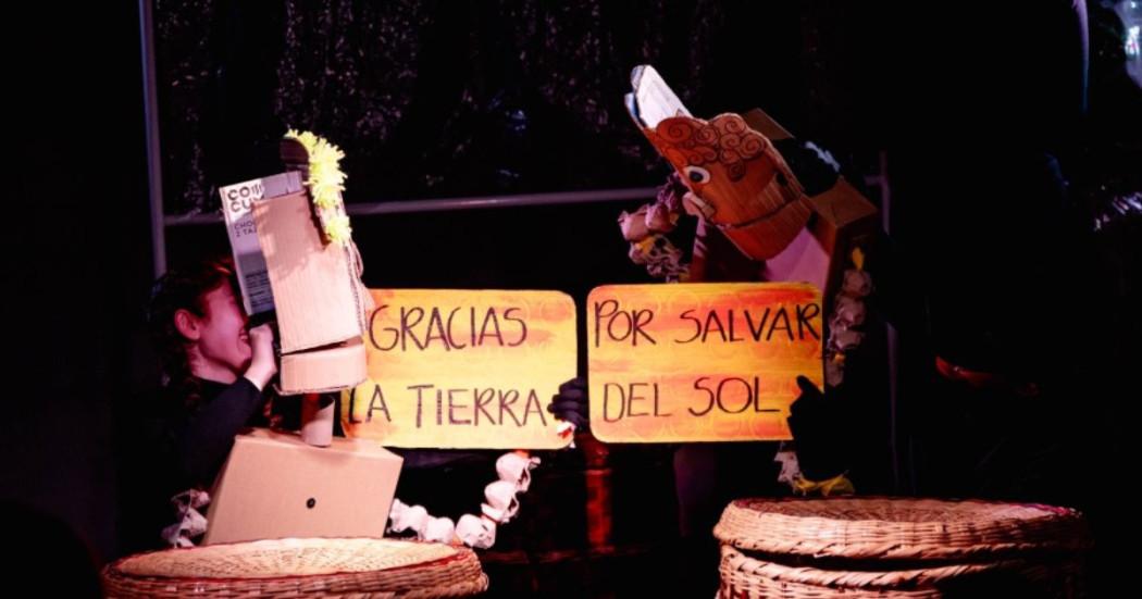 Imagen de dos títeres en cartón con carteles