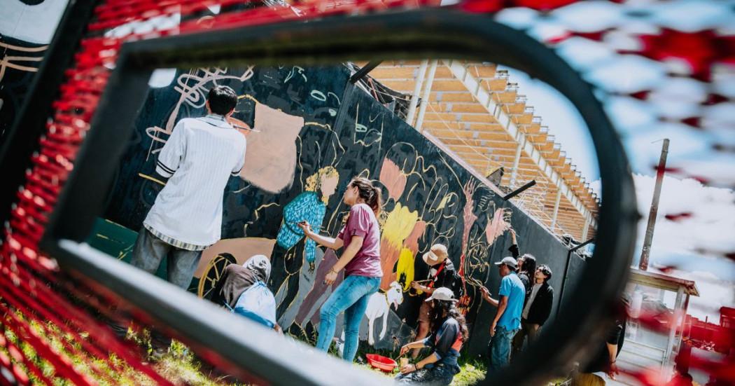 Imagen de personas pintando un mural en la esquina redonda del BDC