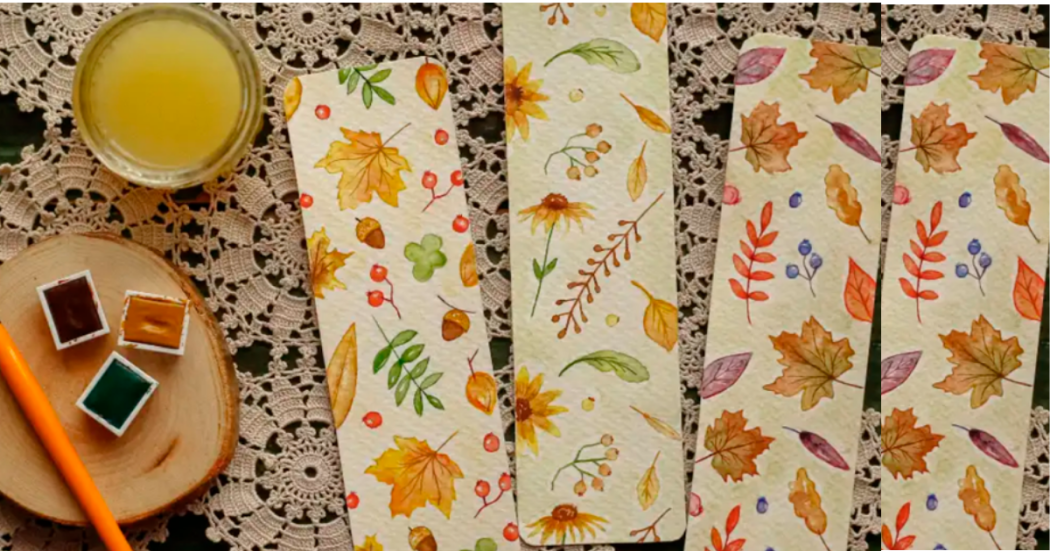 Imagen de una mesa en la que hay unas pinturas, un picnel y tres servilletas con dibujos de flores.