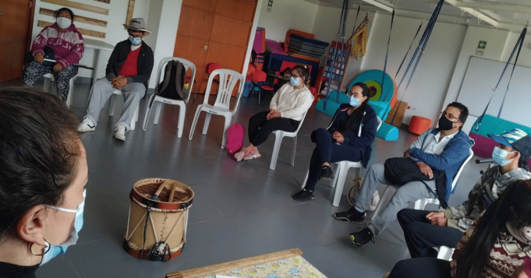 Imagen de varios adultos mayores tomando el taller, en el centro se observa un tambor.