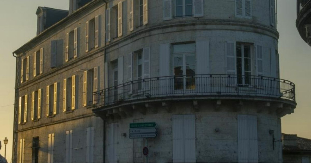 Imagen de la fachada de un edificio antiguo pintado de blanco.
