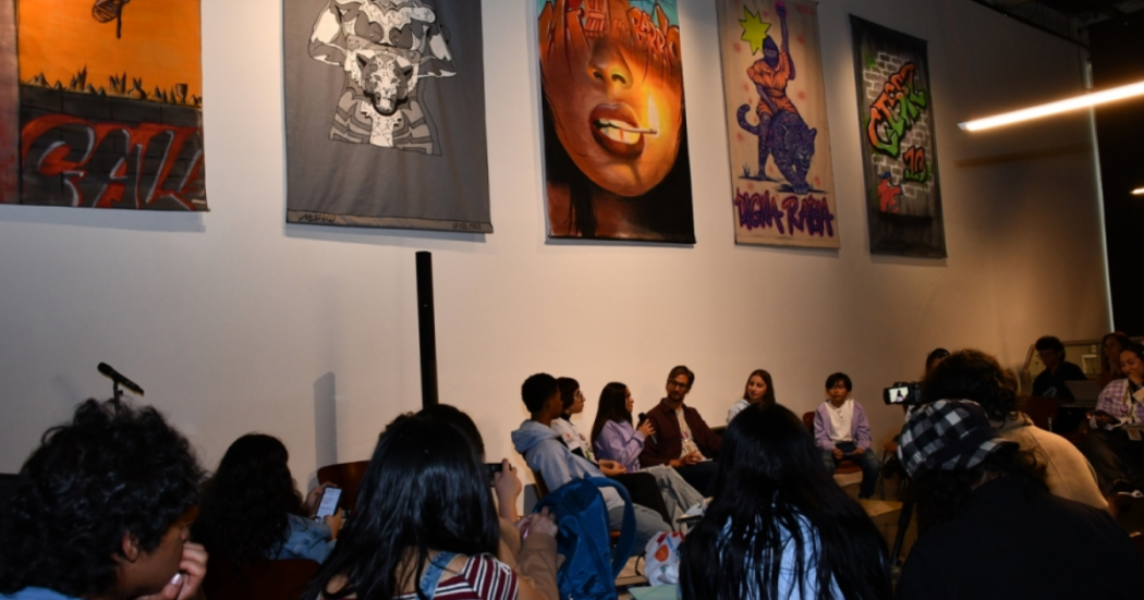 Imagen de varias personas en una sala de exposición sentadas en una charla.