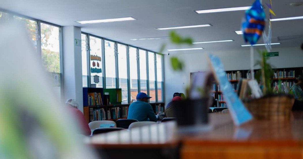 Foto que muestra personas en una biblioteca 
