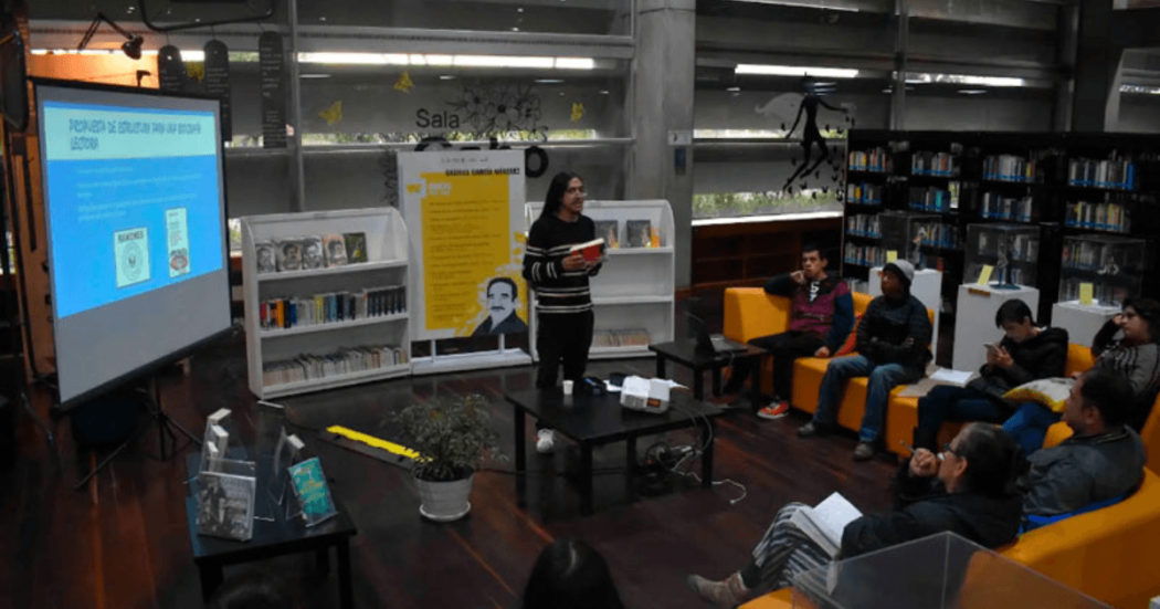 Personas escuchando una conferencia en una biblioteca.