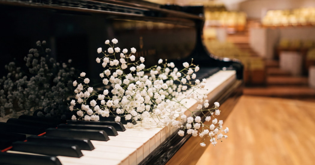 Imagen de piano con flores blancas pequeñas.