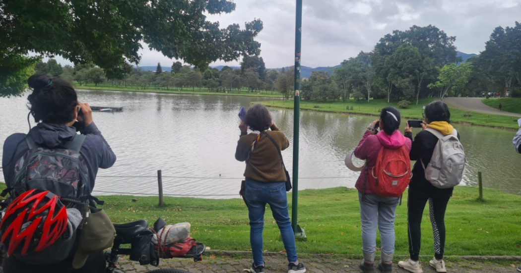 Imagen de personas tomando fotografias del lago en Bosque Urbano El Tunal