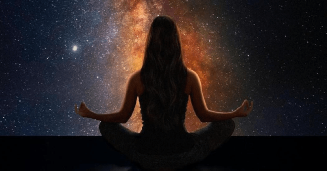 Imagen de una mujer de espaldas practicando yoga con fondo de estrellas.