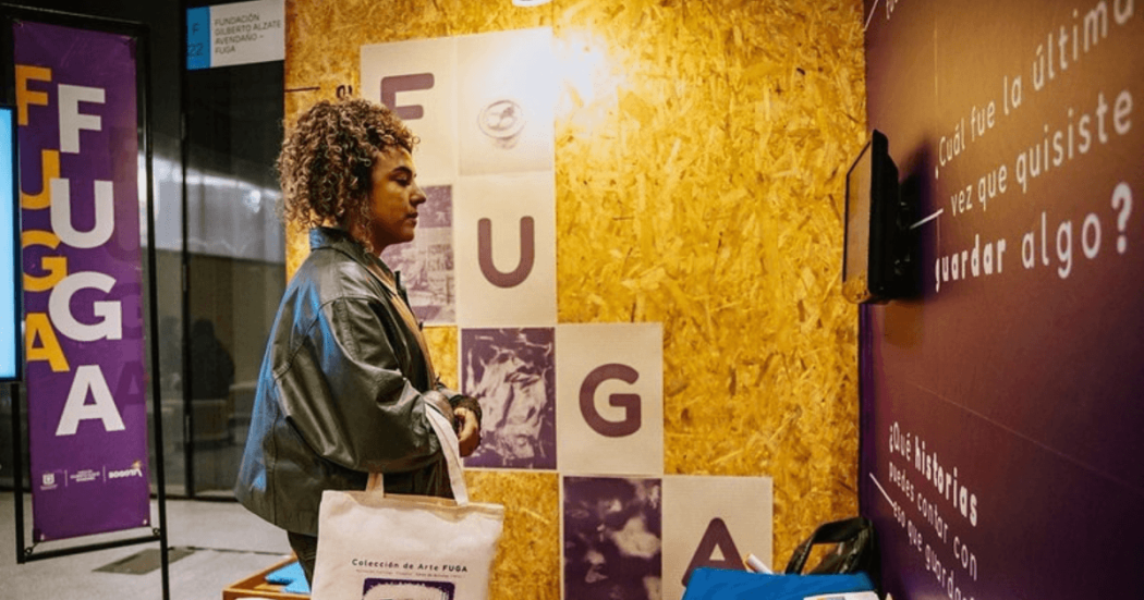 Imagen de stand de la Fuga con una mujer mirando la pantalla en ARTBo 