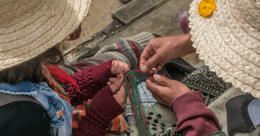 Imagen de dos personas son sombreros hilando